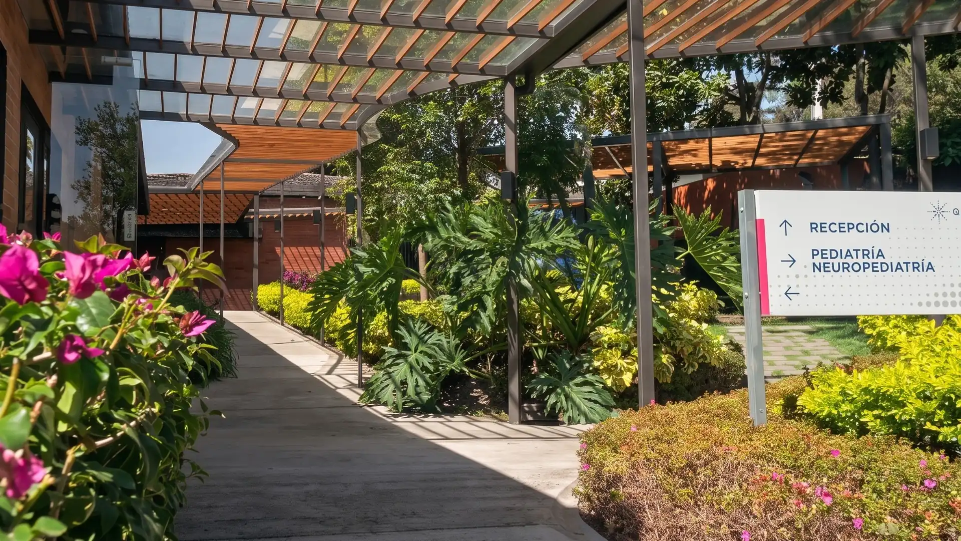 Camino de acceso a Q·RA entre jardines, bajo la pérgola